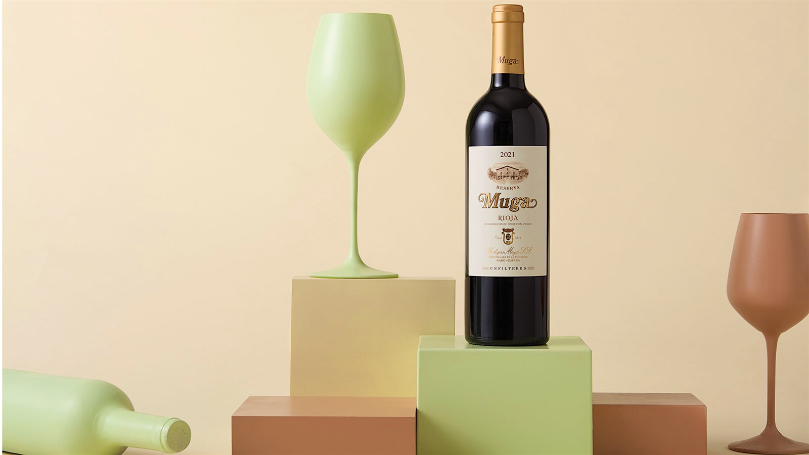 Bodegas Muga Rioja Reserva 2021 displayed in bottle beside an opaque wine glass, colored pastel green.